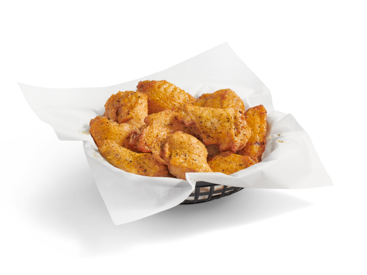 A full basket of crispy, bone-in chicken wings coated in lemon pepper sauce.