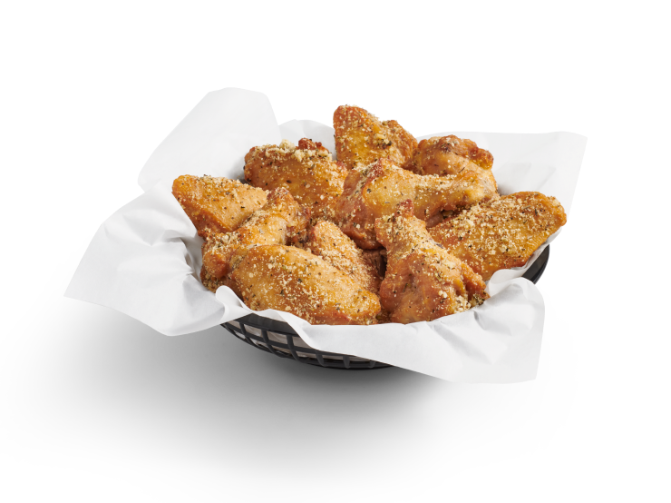 A full basket of crispy, bone-in chicken wings coated in garlic Parmesan sauce.